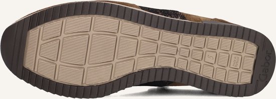 Onderkant van bruine suède sneakers met profielzool.