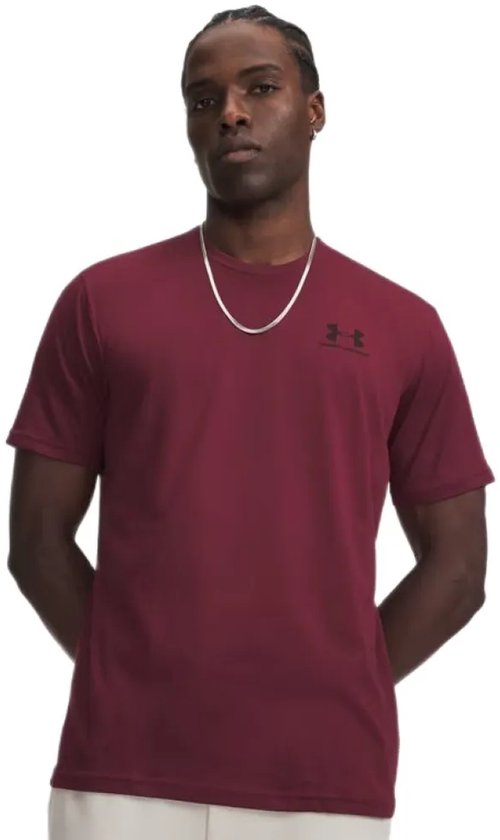 Man met donkere huidskleur draagt een bordeauxrode T-shirt met korte mouwen en zwart Under Armour logo, met zilveren ketting.