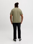 Man, van achteren gezien, draagt een olijfgroen T-shirt en zwarte broek.
