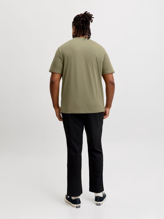 Man, van achteren gezien, draagt een olijfgroen T-shirt en zwarte broek.