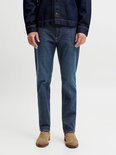 Close-up van de pasvorm van een medium blauwe jeans met een donkerblauw denimjack.