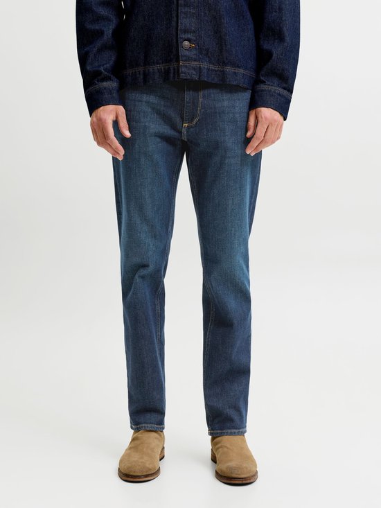 Close-up van de pasvorm van een medium blauwe jeans met een donkerblauw denimjack.