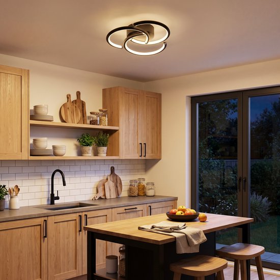 Moderne zwarte plafondlamp met drie ringen in een keuken met houten kasten.