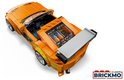 Oranje LEGO Toyota Supra MK4 met zichtbaar interieur, spoiler en groene graphics, vanuit een schuin bovenaanzicht.