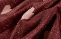 Detail van bordeauxrode stof met roze hartjes en glitter.