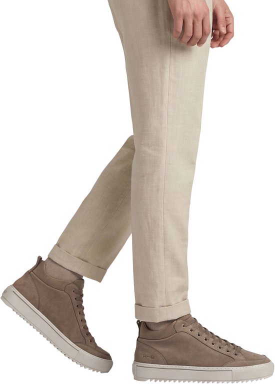 Man met beige broek met omgeslagen pijpen draagt taupe Rehab sneakers met crèmekleurige zolen.