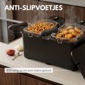 Zwarte dubbele frituurpan met anti-slipvoetjes, vol met frietjes en snacks. Blijft veilig op zijn plek.