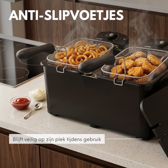 Zwarte dubbele frituurpan met anti-slipvoetjes, vol met frietjes en snacks. Blijft veilig op zijn plek.