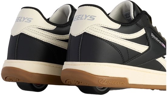 Achterkant van zwarte Heelys sneakers met crèmekleurige hiel en accenten, en op de zool gemonteerde rollen.