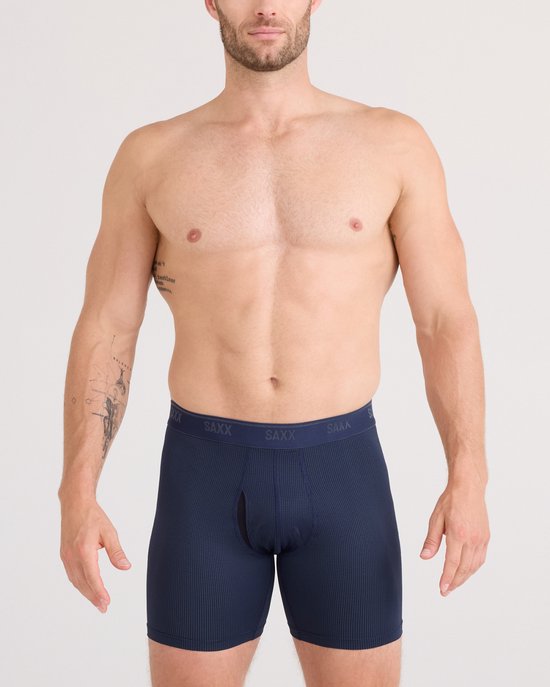 Vooraanzicht van een man die een donkerblauwe SAXX boxershort met ruitjespatroon en SAXX-band draagt, met opening.