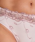 Detail van roze hoge slip met bloemenborduurwerk en strikje.
