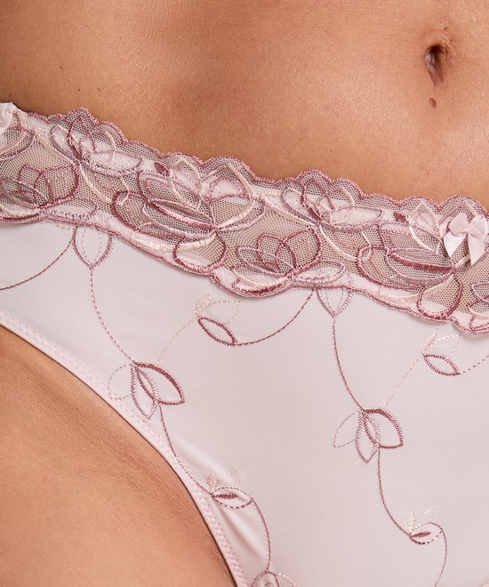 Detail van roze hoge slip met bloemenborduurwerk en strikje.