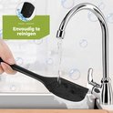 Une spatule raclette en silicone noir est nettoyée sous un robinet dans un évier.