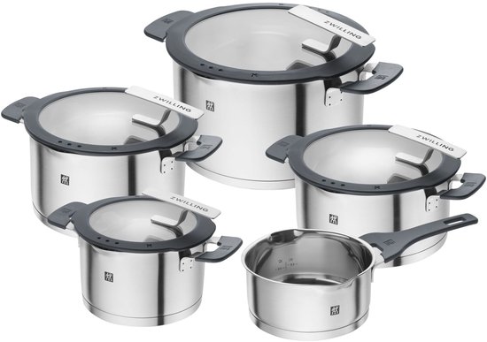 Een set van vijf roestvrijstalen kookpotten en een steelpan met glazen deksels en grijze handvatten.