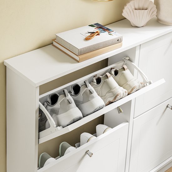 Witte schoenenkast met open vakken, gevuld met diverse schoenen, inclusief sneakers.