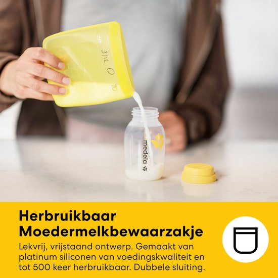 Gele, herbruikbare moedermelk bewaarzak van siliconen, met dubbele sluiting, die melk in een Medela flesje giet.