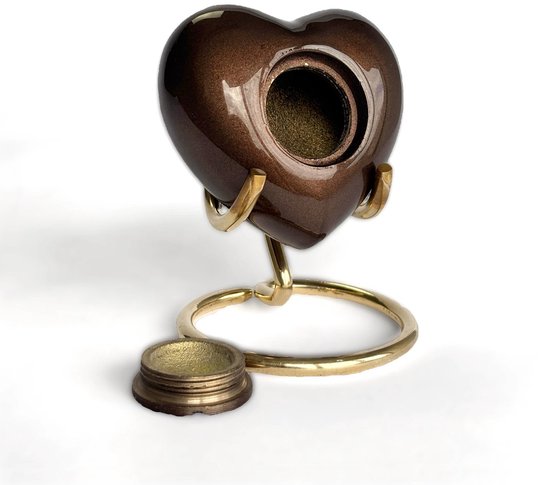 Bruine glanzende hartvormige urn met open schroefdop en gouden standaard.