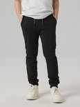 Jongen draagt zwarte joggingbroek met grijze trekkoorden.
