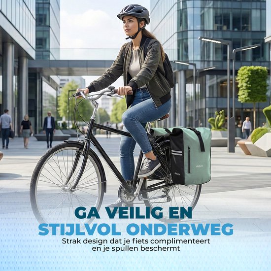 Vrouw op een zwarte fiets met mintgroene dubbele fietstas in een stedelijke omgeving. Tekst: 'Ga veilig en stijlvol onderweg'.