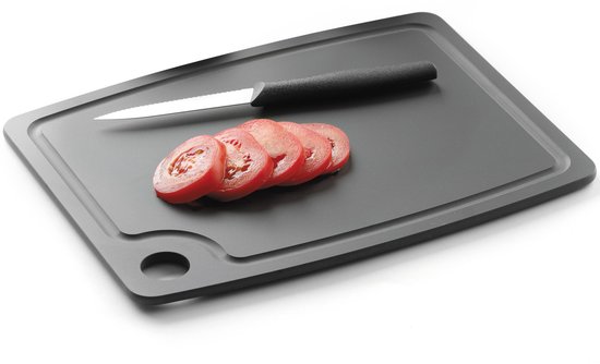Zwarte snijplank met vijf plakjes tomaat en een mes.