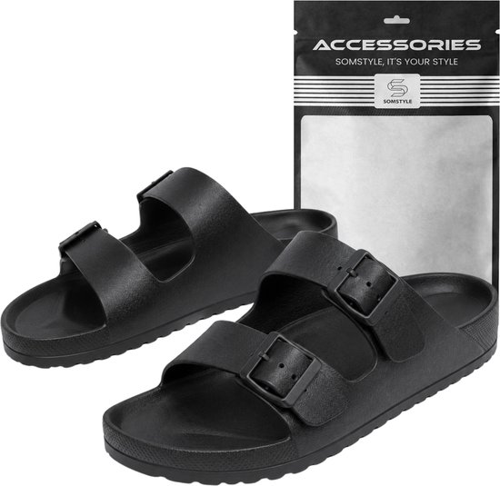 Zwarte Somstyle slippers met dubbele gesp en zilverkleurig logo op de verpakking.