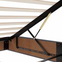 Close-up van de scharnierende metalen liftconstructie en houten latten van het donkergrijze bedframe.