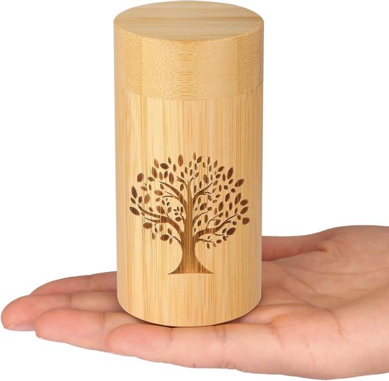 Houten urn met levensboompatroon in een hand.