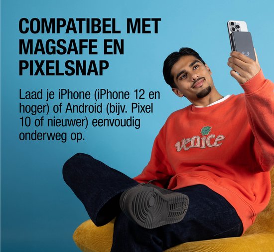 Jongeman met oranje trui laadt iPhone op met rode magnetische powerbank.