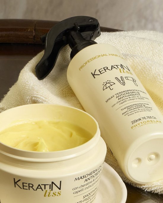 Crème pot en sprayfles met het Keratin Liss logo, naast een witte handdoek.