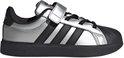 Zilveren Adidas sneaker met zwarte strepen, veters en klittenband.