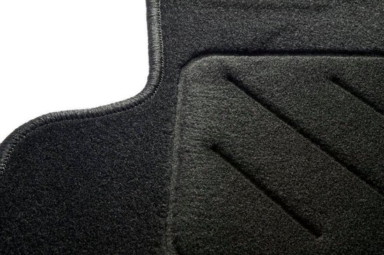 Gros plan sur un tapis de sol de voiture noir avec une zone de repose-pied texturée.