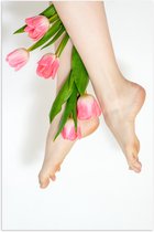Poster Glanzend – Bos Roze Tulpen Tussen Vrouwelijke Benen tegen Witte Achtergrond - 70x105 cm Foto op Posterpapier met Glanzende Afwerking