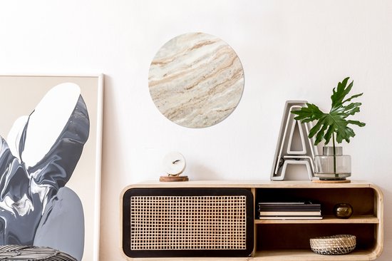 Ronde wanddecoratie met een marmerlook patroon in beige, bruin en wit tinten.