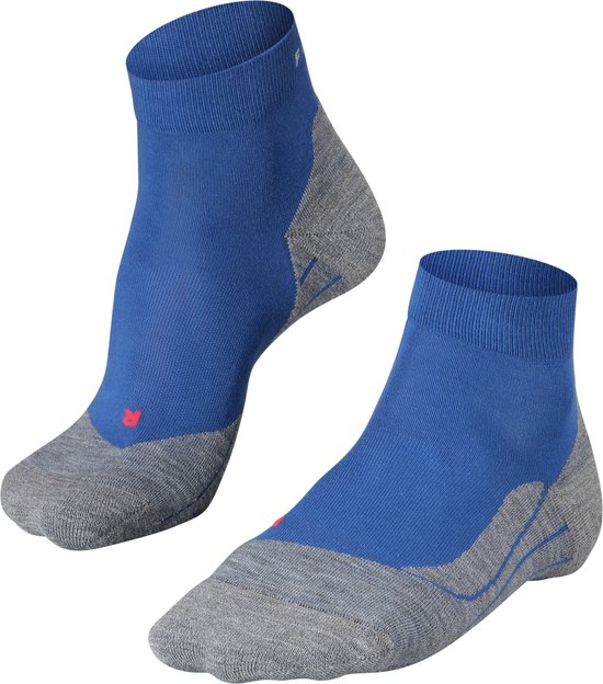 Paar blauwe en grijze Falke sportsokken, de ene op een voet, de andere los.