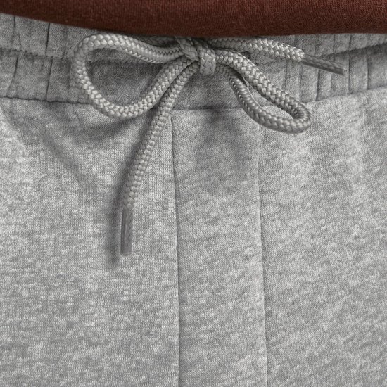 Sluit detail van de strik van het trekkoord van een lichtgrijze joggingbroek.