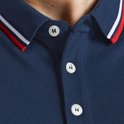 Detail van de kraag van een donkerblauwe polo met rode en witte strepen en witte knopen.