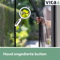 Een hand opent het zwarte magnetische vliegengordijn, met een vergrootglas op een insect.