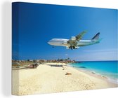 Canvas Schilderij Een vliegtuig vliegt vlak over Maho Bay Beach op Sint Maarten - 40x30 cm - Wanddecoratie