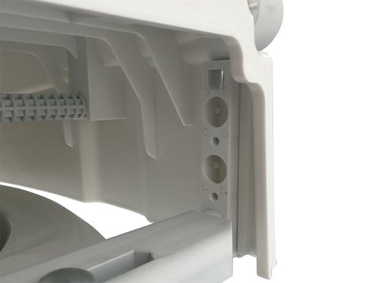 Detail van de bevestigingsmechanisme aan de onderkant van een witte toiletverhoger.