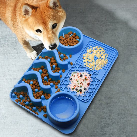 Een Shiba Inu hond kijkt naar een blauwe siliconen snuffelmat gevuld met verschillende soorten voer.