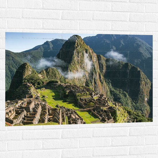 WallClassics - Muursticker - Uitzicht over Dorpje Machu Picchu in Peru - 105x70 cm Foto op Muursticker