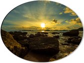 Dibond Ovaal - Felkleurige Zonsondergang boven de Zee aan het Strand vol Rotsen - 40x30 cm Foto op Ovaal (Met Ophangsysteem)