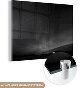 MuchoWow® Glasschilderij 80x60 cm - Schilderij acrylglas - Noorderlicht boven hut - zwart wit - Foto op glas - Schilderijen