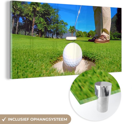 MuchoWow® Glasschilderij 80x40 cm - Schilderij acrylglas - Een golfer put de bal in de hole - Foto op glas - Schilderijen