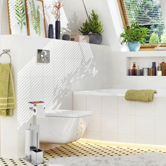 Zilverkleurige toiletrolhouder met plankje en wc-borstel, in een lichte badkamer met planten.