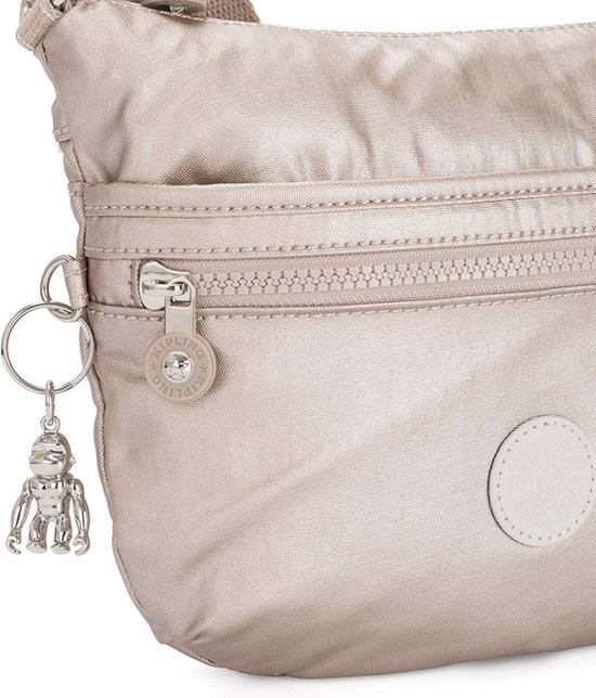 Detail van de zilverkleurige rits en aapjeshanger aan een lichtgrijze Kipling tas.