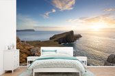 Behang - Fotobehang Rotsen en zee bij zonsondergang op het eiland Skye in Schotland - Breedte 450 cm x hoogte 300 cm