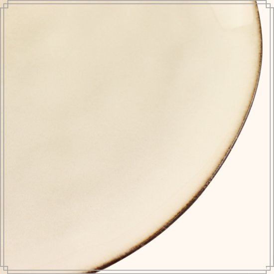 Close-up van een beige dinerbord met een verweerde gouden rand.