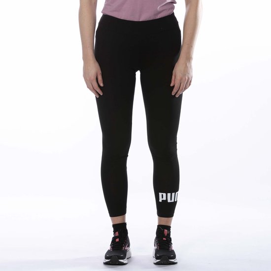 Gedeeltelijk beeld van een vrouw in zwarte legging met groot wit Puma-logo op de zijkant van de broekspijp.