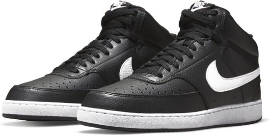Paar zwarte Nike Court Vision Mid sneakers met witte Nike logo's op de zijkant en witte zolen.